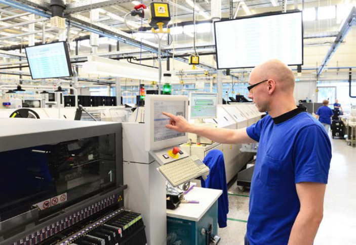 Teollisuusympäristö, työntekijä ohjaamassa.